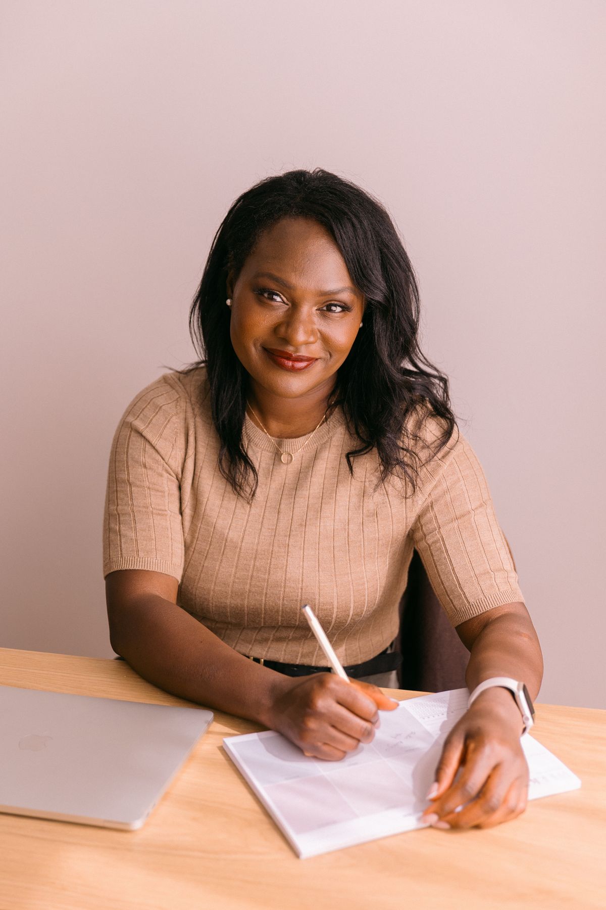 Rozella smiling at the camera while writing in her planner
